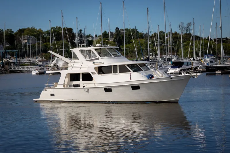 The Image of 2019 Marlow Explorer 49E yacht docked in a marina, surrounded by sailboats. - 0