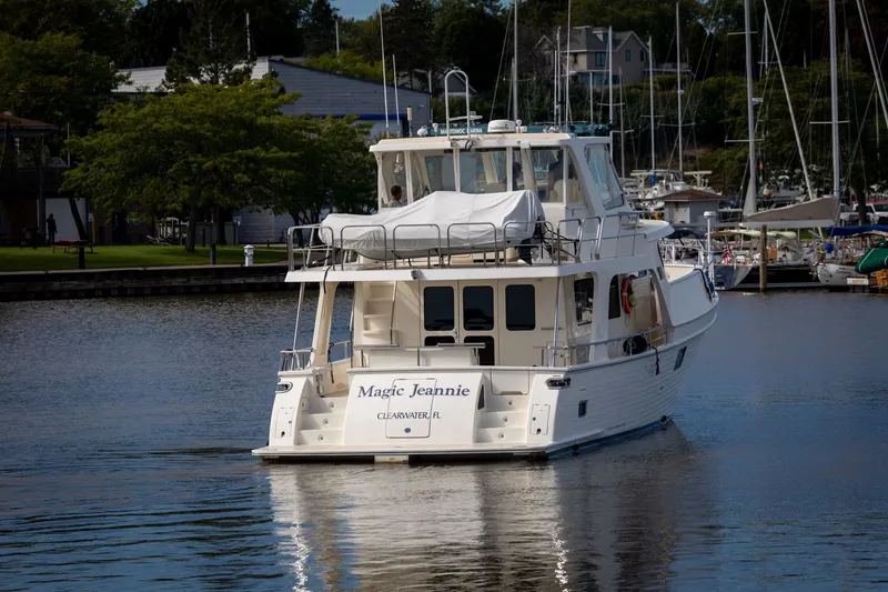 Slide: The Image of 2019 Marlow Explorer 49E yacht docked in a marina, surrounded by trees and boats. - 3
