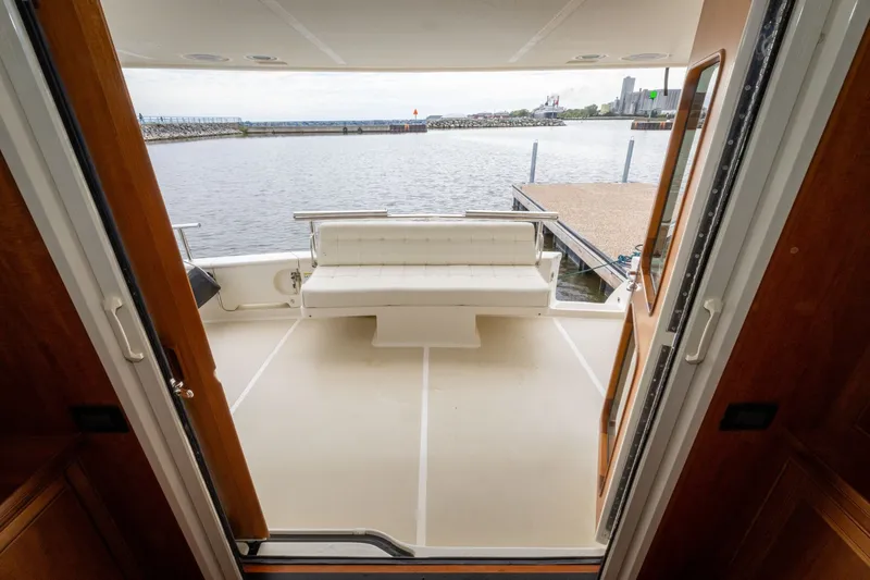 Slide: The Image of 2019 Marlow Explorer 49E yacht deck with seating, overlooking a serene waterfront. - 30