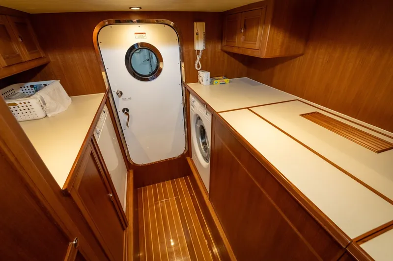 Slide: The Image of Laundry room on 2019 Marlow Explorer 49E yacht with wood paneling and washer. - 69