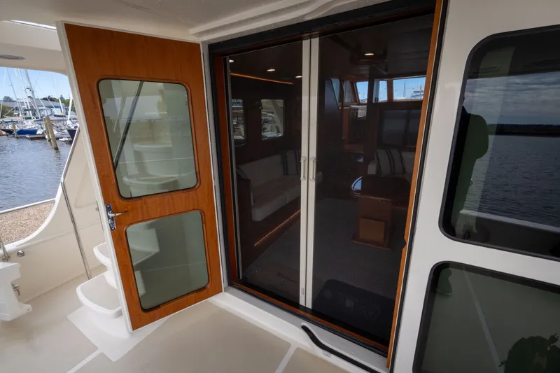 Slide: The Image of 2019 Marlow Explorer 49E yacht interior with open wooden door and glass sliding doors. - 29