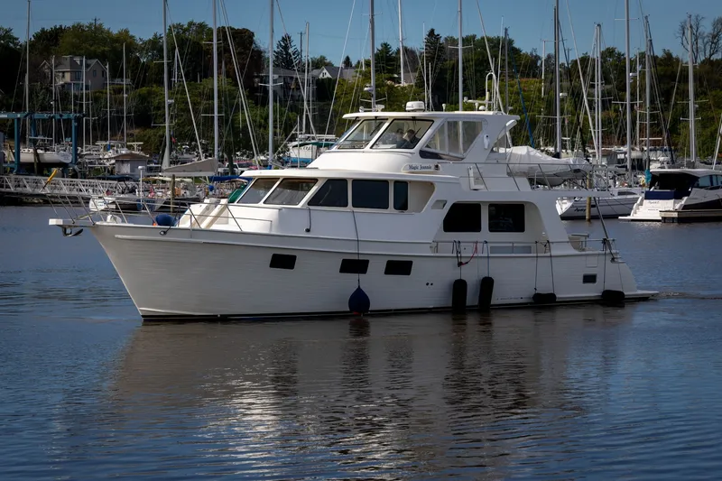 Slide: The Image of 2019 Marlow Explorer 49E yacht docked in a marina with sailboats in the background. - 8