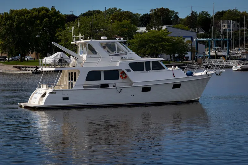 Slide: The Image of 2019 Marlow Explorer 49E yacht docked in a serene marina setting. - 1