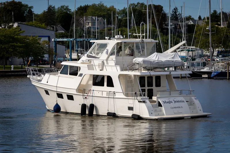 Slide: The Image of 2019 Marlow Explorer 49E yacht docked in a marina, surrounded by sailboats. - 6