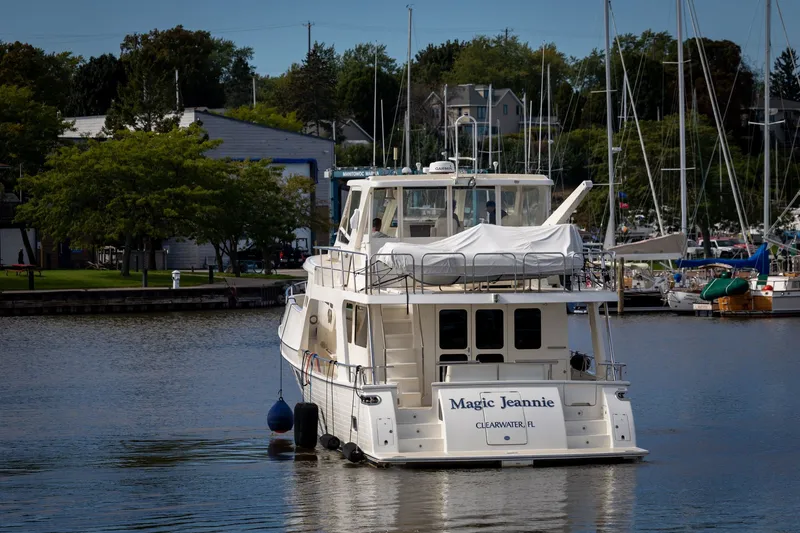 Slide: The Image of 2019 Marlow Explorer 49E yacht docked in a marina, surrounded by trees and boats. - 5