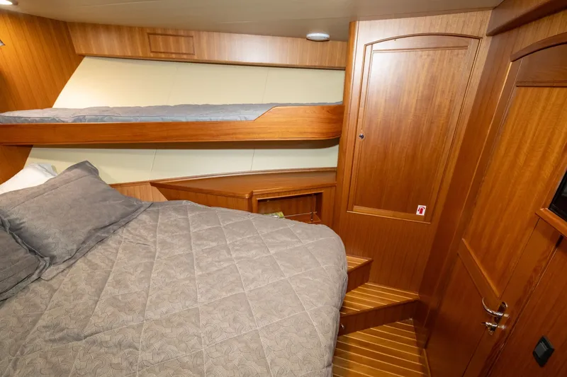 Slide: The Image of Cozy cabin interior of 2019 Marlow Explorer 49E with wooden finishes and bunk beds. - 63