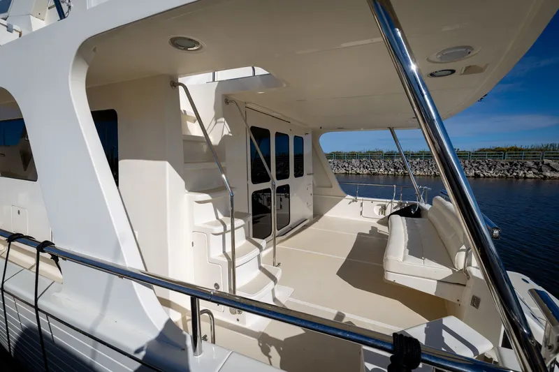 Slide: The Image of 2019 Marlow Explorer 49E yacht deck with seating and stairs, docked by water. - 16
