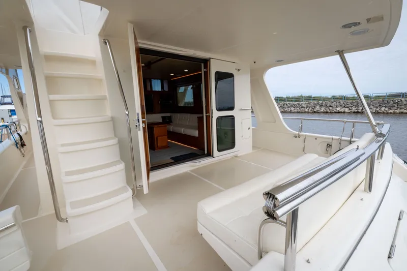 Slide: The Image of 2019 Marlow Explorer 49E yacht interior with seating, stairs, and open cabin view. - 27