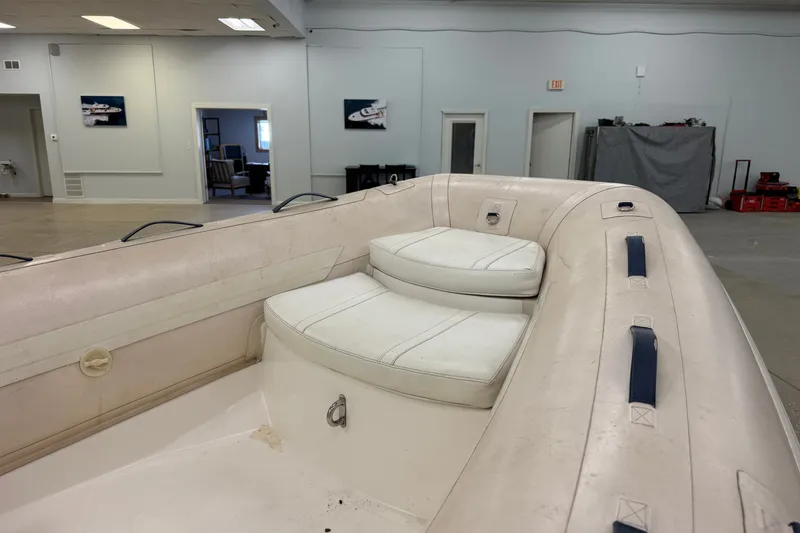 Slide: The Image of 2004 Nautica RIB 15 WIDEBODY inflatable boat interior with white seating in a showroom. - 20