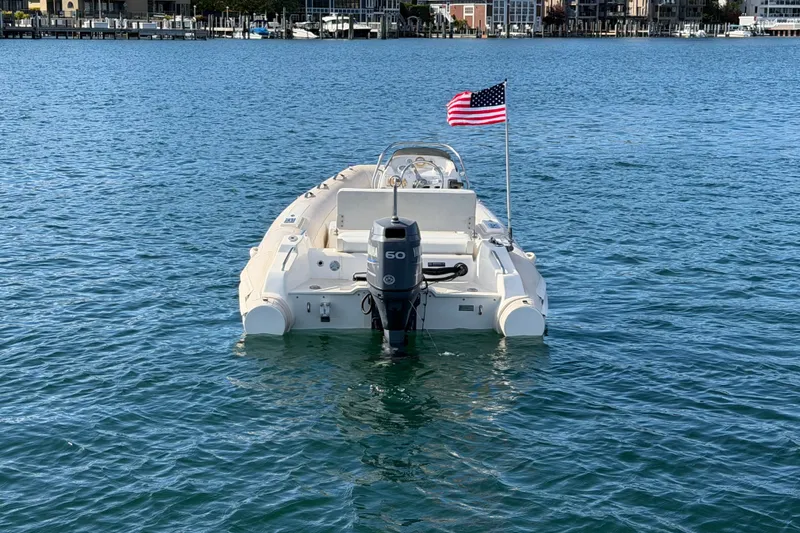 Slide: The Image of 2004 Nautica RIB 15 Widebody boat with American flag on water. - 6