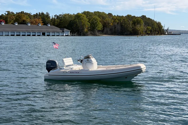 Slide: The Image of 2004 Nautica RIB 15 Widebody boat on calm water with scenic background. - 4