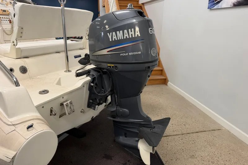 Slide: The Image of 2004 Nautica RIB 15 Widebody with Yamaha 60HP outboard motor in a garage setting. - 16