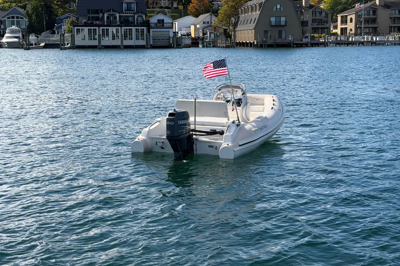Slide: The Image of 2004 Nautica RIB 15 Widebody boat with American flag on water. - 5