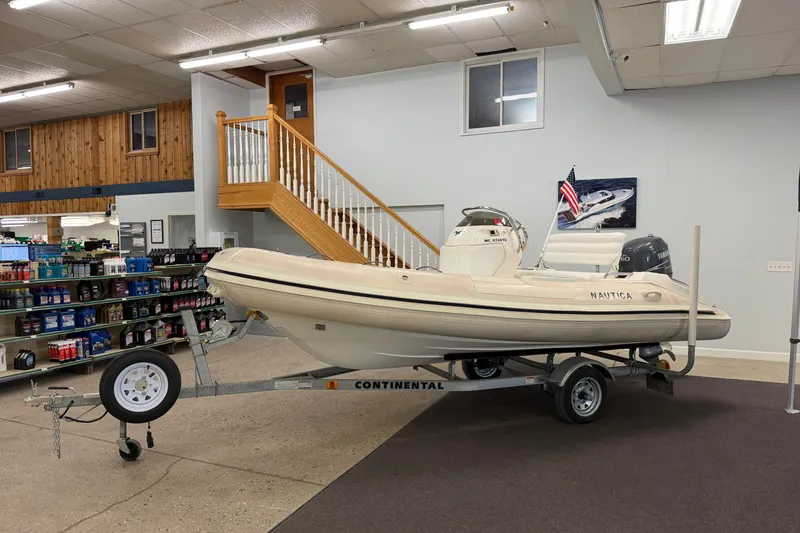 Slide: The Image of 2004 Nautica RIB 15 Widebody boat displayed indoors on a trailer. - 15