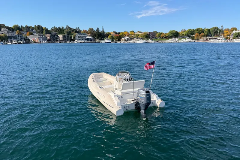 Slide: The Image of 2004 Nautica RIB 15 Widebody boat on calm water with American flag. - 7