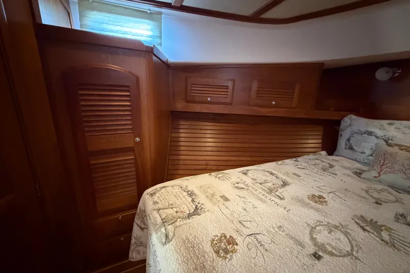 Slide: The Image of Interior cabin of 2010 Sabre 40 Sedan with wooden paneling and patterned bedding. - 19