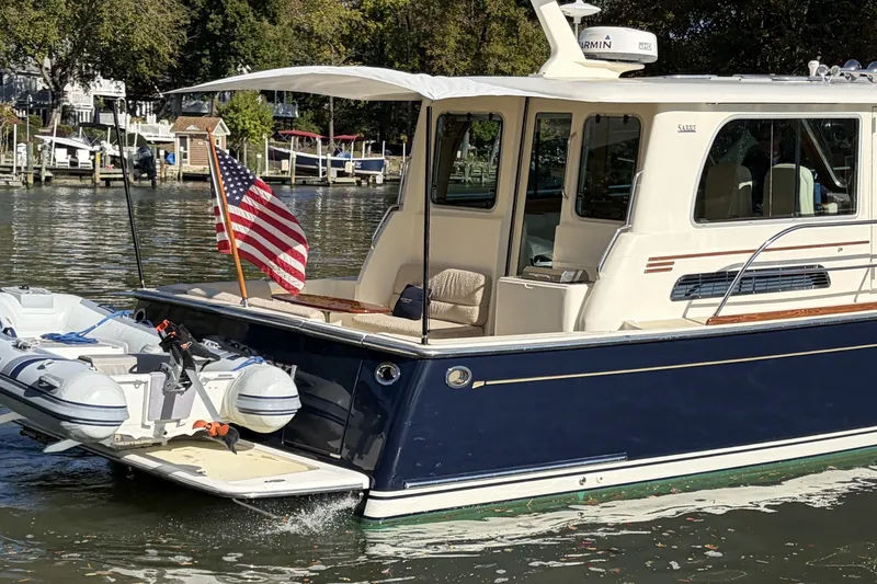 Slide: The Image of 2010 Sabre 40 Sedan yacht with American flag, docked on a sunny day. - 3