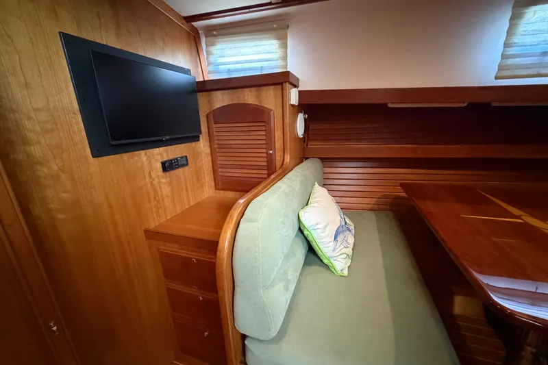 Slide: The Image of Interior of 2010 Sabre 40 Sedan with TV, wooden cabinetry, and cushioned seating. - 17