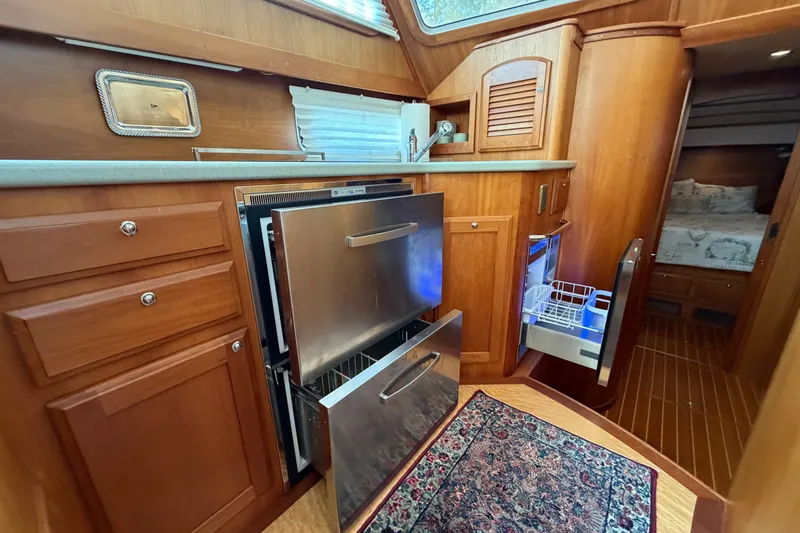 Slide: The Image of 2010 Sabre 40 Sedan yacht interior with wooden cabinetry and modern kitchen appliances. - 21