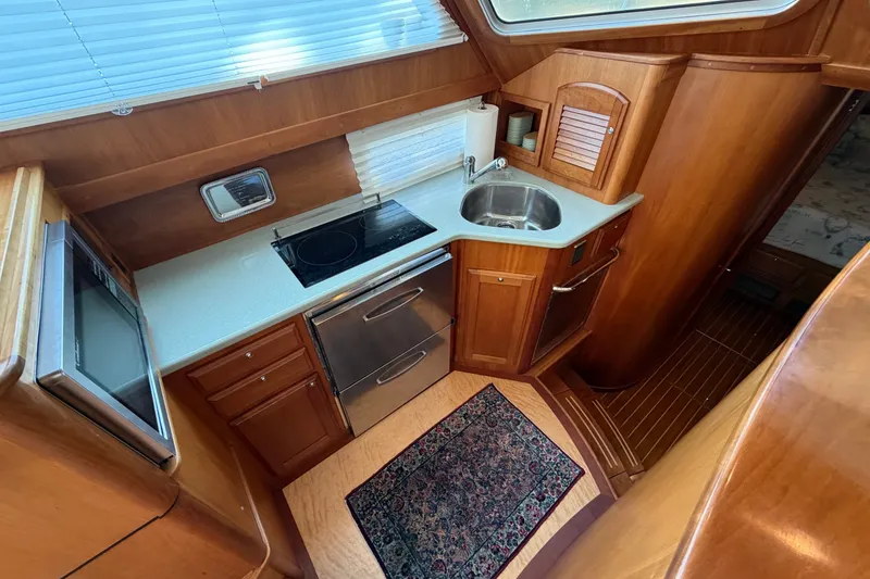 Slide: The Image of Compact kitchen in 2010 Sabre 40 Sedan yacht with wood cabinetry and modern appliances. - 22