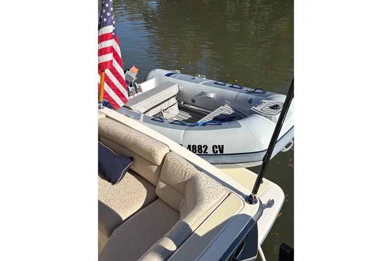 Slide: The Image of 2010 Sabre 40 Sedan with inflatable boat and American flag on calm water. - 9