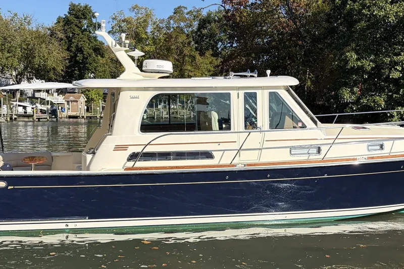 Slide: The Image of 2010 Sabre 40 Sedan yacht on a calm river, surrounded by trees. - 2