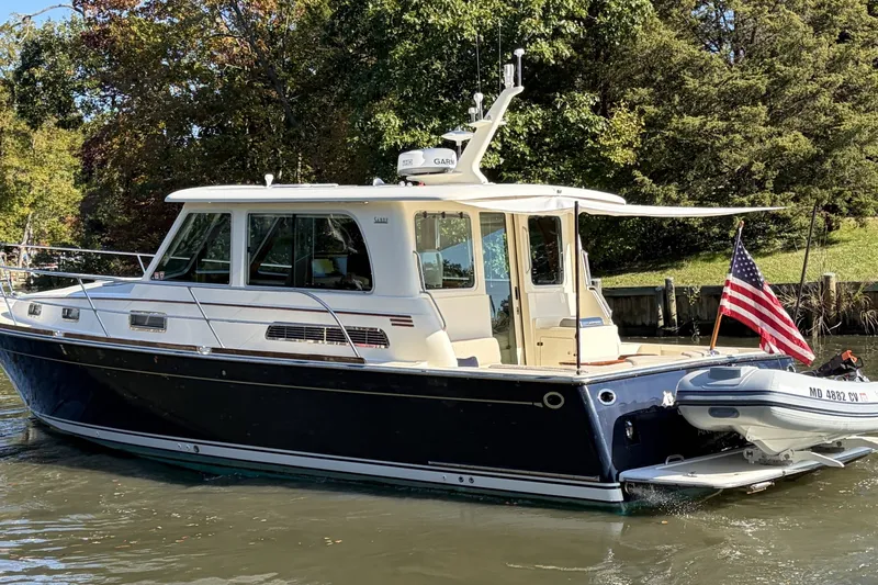 Slide: The Image of 2010 Sabre 40 Sedan boat with American flag on calm water. - 5