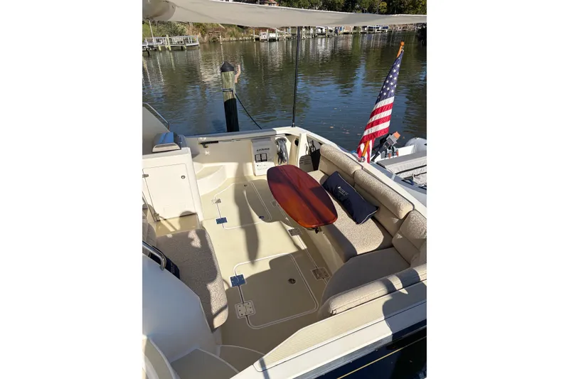 Slide: The Image of 2010 Sabre 40 Sedan boat deck with seating, table, and American flag by the water. - 6