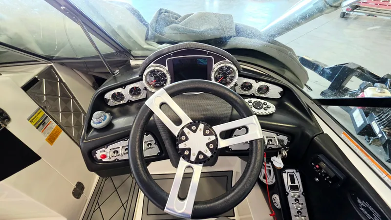 Slide: The Image of The cockpit of a 2010 MasterCraft X-55 with a modern steering wheel and instruments. - 3