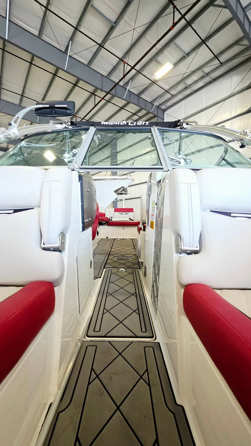 Slide: The Image of The image shows the interior of a 2010 MasterCraft X-55 boat with red seating. - 9