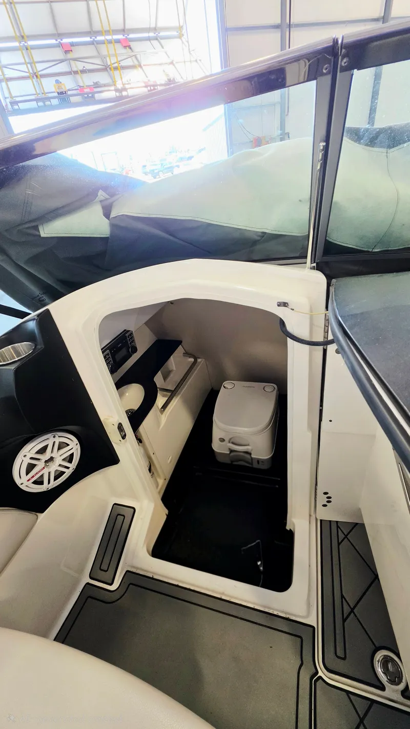 Slide: The Image of Interior view of a 2010 MasterCraft X-55 boat with seating area and portable toilet. - 5