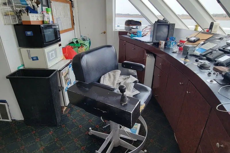 Slide: The Image of 1978 Blount Passenger ship's bridge with control chair, navigation equipment, and office supplies. - 18