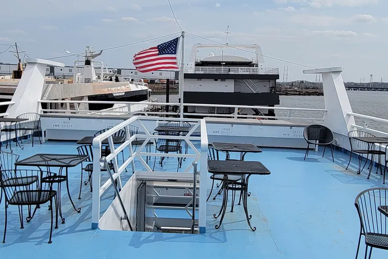 Slide: The Image of 1978 Blount passenger vessel deck with tables, chairs, and American flag. - 15