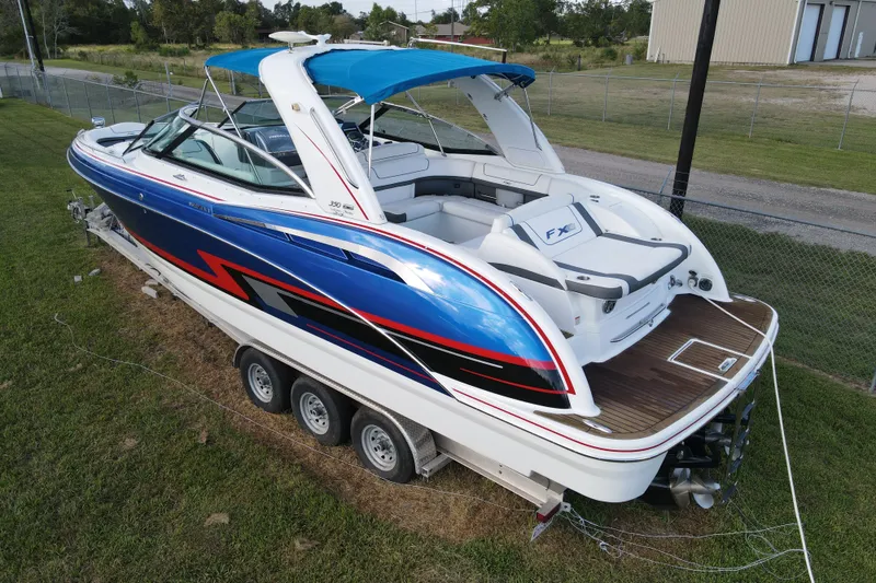 Slide: The Image of 2015 Formula 350 FX Crossover Bowrider with blue and white design on a trailer. - 16