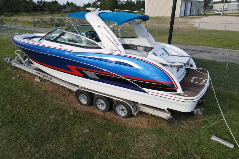 Slide: The Image of 2015 Formula 350 FX Crossover Bowrider on trailer, vibrant blue and red design. - 15