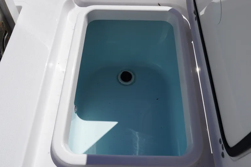 Slide: The Image of Livewell compartment on 2024 Sportsman Masters 267OE Bay Boat, featuring a clean, blue interior. - 19