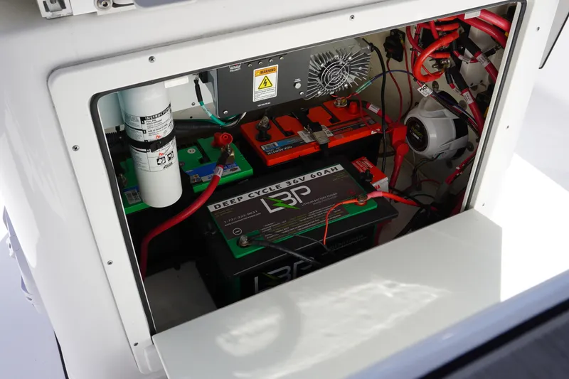 Slide: The Image of 2024 Sportsman Masters 267OE Bay Boat battery compartment with wiring and deep cycle battery. - 55