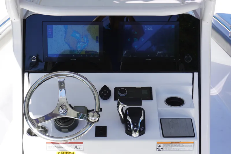 Slide: The Image of 2024 Sportsman Masters 267OE Bay Boat dashboard with dual Garmin displays and steering wheel. - 30