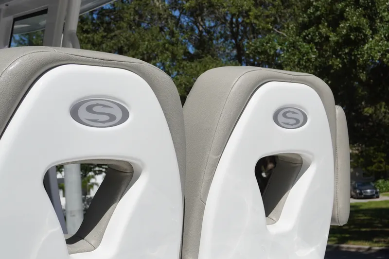 Slide: The Image of 2024 Sportsman Masters 267OE Bay Boat seats with logo, outdoor setting. - 26