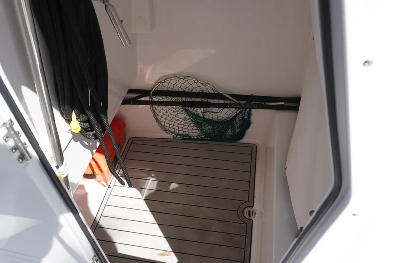 Slide: The Image of 2024 Sportsman Masters 267OE Bay Boat storage area with fishing net and equipment. - 54