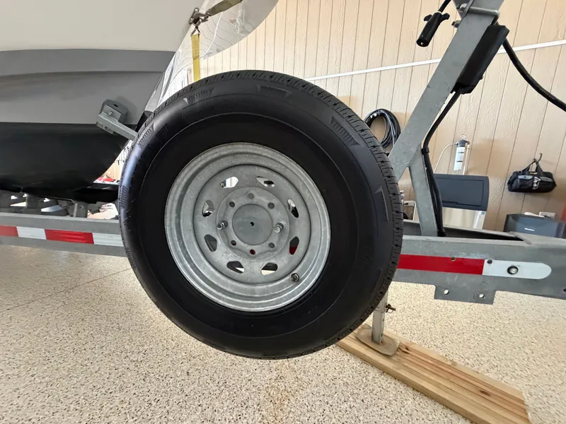 Slide: The Image of A boat trailer with a large wheel resting on a wooden block. - 39