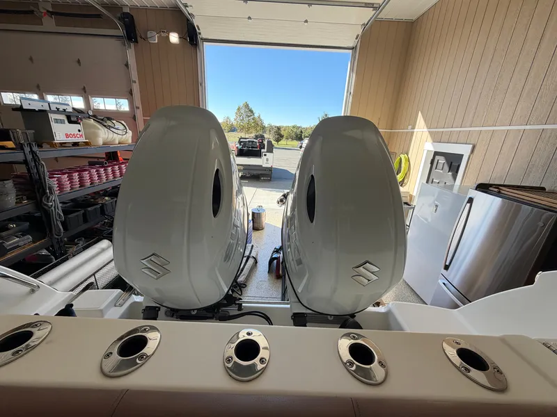 Slide: The Image of Two outboard motors on a boat in a garage, facing outside. - 33
