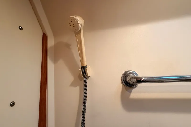 Slide: The Image of Shower area in 2001 Mainship Pilot 34 boat, featuring handheld showerhead and towel bar. - 30