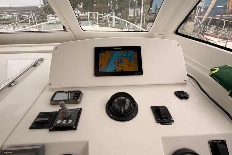 Slide: The Image of 2001 Mainship Pilot 34 helm with navigation equipment and compass in marina setting. - 20