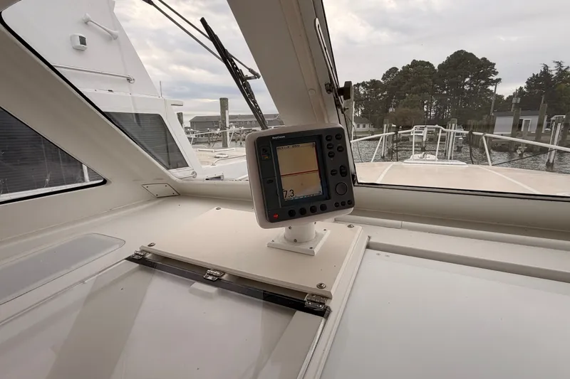 Slide: The Image of 2001 Mainship Pilot 34 boat cockpit with navigation display, docked at marina. - 19