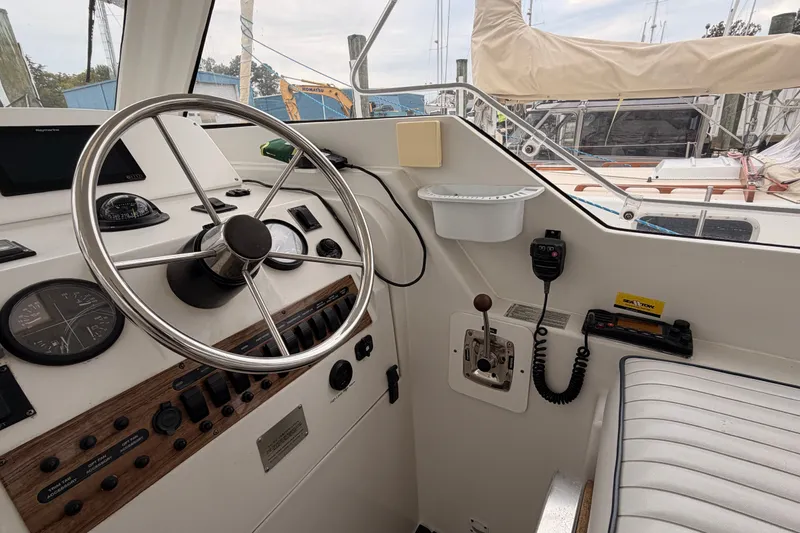 Slide: The Image of 2001 Mainship Pilot 34 helm with steering wheel, controls, and navigation instruments. - 14