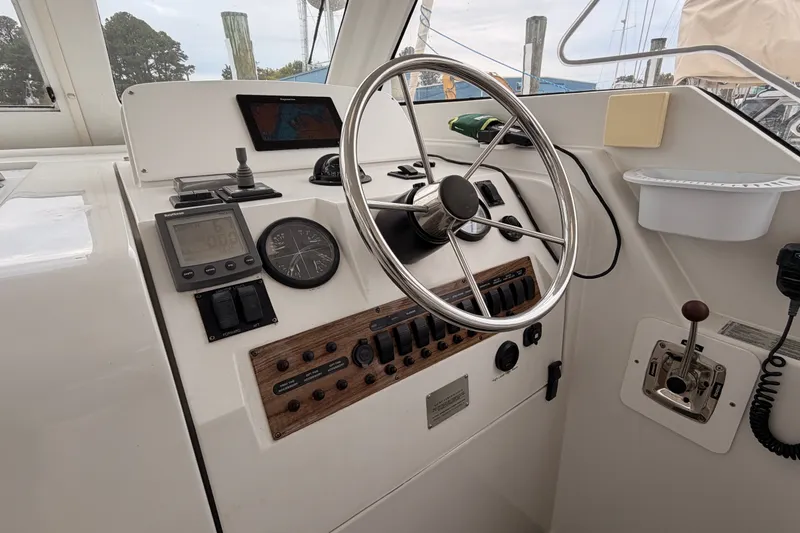 Slide: The Image of 2001 Mainship Pilot 34 helm with steering wheel, navigation instruments, and control panel. - 17