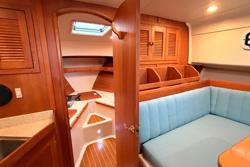 Slide: The Image of Interior of 2001 Mainship Pilot 34 boat with wood finish and blue seating. - 32