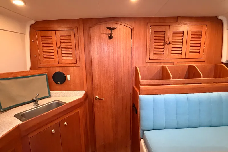 Slide: The Image of Interior of 2001 Mainship Pilot 34 with wood cabinetry and blue seating. - 31