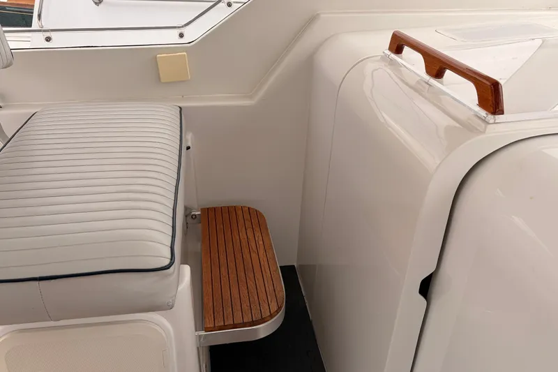 Slide: The Image of 2001 Mainship Pilot 34 interior with cushioned seating and wooden accents. - 21